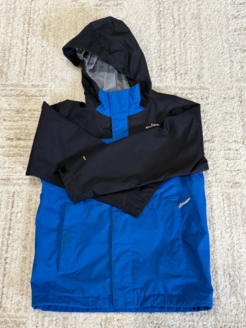 The North Face 
Boys Blue and Black Jacket Tag Detail